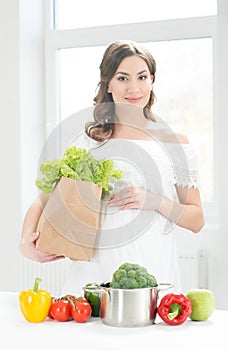 Beautiful pregnant woman with a shopping bag