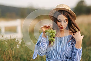 Beautiful pregnant woman show and eat green grapes. Healthy food. Fresh fruits. Happy woman smile