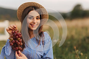 Beautiful pregnant woman show and eat red grapes. Healthy food. Fresh fruits. Happy woman smile