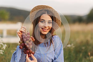 Beautiful pregnant woman show and eat red grapes. Healthy food. Fresh fruits. Happy woman smile