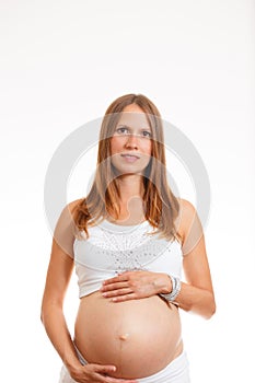 Beautiful pregnant woman smiling and touching her belly