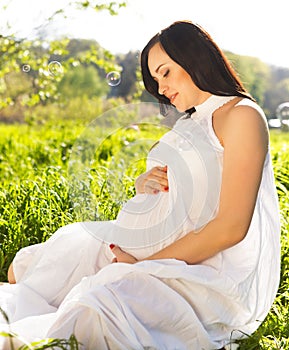 Beautiful pregnant woman in the spring park