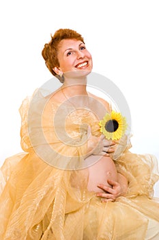 Beautiful pregnant woman with a sunflower