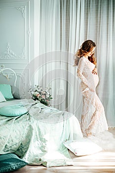 Beautiful pregnant woman in their bedroom