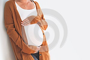 Close-up pregnant woman touching her belly. Mother anticipation photo