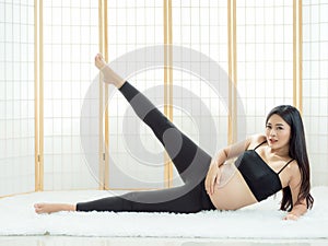 Beautiful pregnant women sit on the floor in Japanese room and relax with yoga exercise