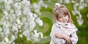 Beautiful preteen girl with long blond hair enjoy spring apple blooming. Little preschool girl in garden tree flowers. Springtime