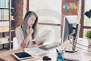 Beautiful pretty charming cute with modern hairstyle agent secretary trainee checking documents in hand looking at the monitor si