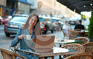 Beautiful professional ht manager woman in a fashion business suit working on a laptop and drinking coffee