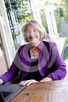 A beautiful professional senior woman working on her laptop from home