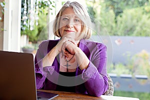 A beautiful professional senior woman working on her laptop from home