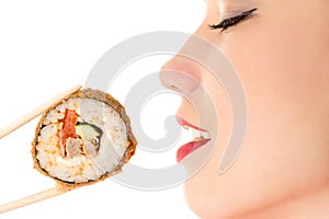 Beautiful profile face girl eating sushi roll closeup