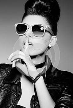 Beautiful punk woman model wearing sun glasses and leather jacket