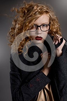 Beautiful pussy-haired girl in a coat and glasses