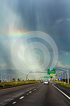 Beautiful rainbow above highway in rainy day