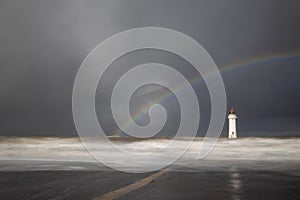A beautiful rainbow appears over lighthouse
