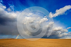 A beautiful rainbow during a heavy storm and rain. The concept of severe weather