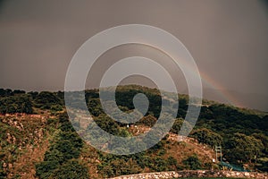 Beautiful rainbow  and natural landscape in Tepotzotlan, State of Mexico, where you can see the mountains, a cloudy sky photo