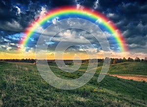 Beautiful rainbow over the field. Agricultural landscape