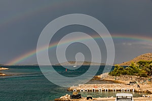 Beautiful rainbow over an island in the Adriatic Sea. Rainbow after a storm at sea