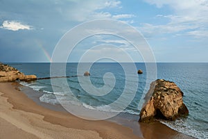 Beautiful rainbow over the Praia dos Tres Castelos in Portimao, Portugal