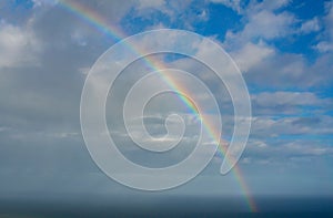 Beautiful rainbow over the sea with clouds