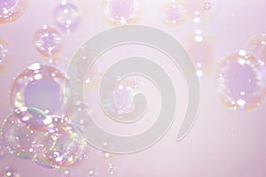 Beautiful rainbow pink soap bubbles float background.