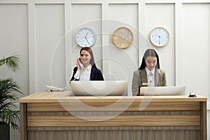 Beautiful receptionists working at counter in hotel