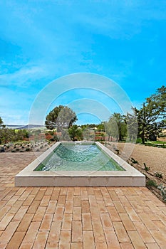 a beautiful recreational pool at the foot of a large garden with spectacular views