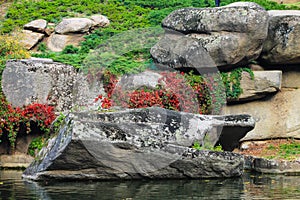 Beautiful red autumn leaves and large stones in a picturesque landscape Sophia park in the Ukrainian city of Uman in the