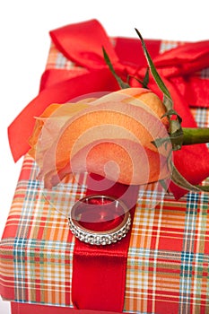 Beautiful red box with red bow, orange rose and engagement ring