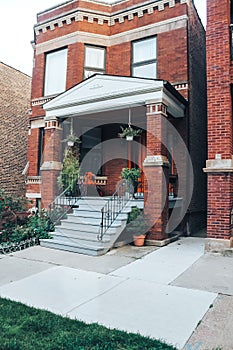 Beautiful red brick house with a large porch and a gas with flowers