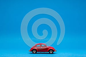 Beautiful red car figurine isolated on blue background
