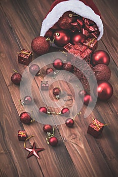 Beautiful red decorative balls, stars and gift boxes in santahat, lay on wood board with copy space