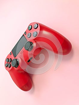 Beautiful red digital modern new game joystick for computer video games gamepad on a pink background