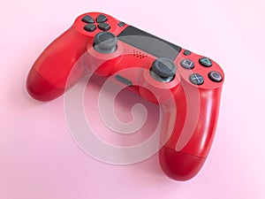 Beautiful red digital modern new game joystick for computer video games gamepad on a pink background