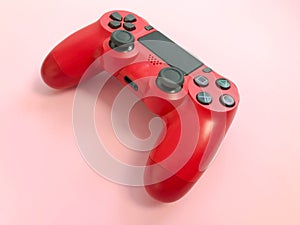 Beautiful red digital modern new game joystick for computer video games gamepad on a pink background