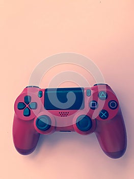 Beautiful red digital modern new game joystick for computer video games gamepad on a pink background