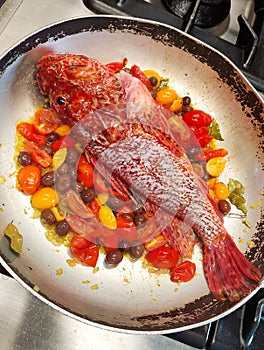 Beautiful red fish with olives and cherry italian tomatoes