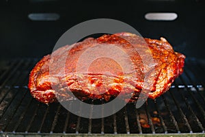 A beautiful red glazed pork shoulder on the grill.