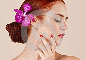 Beautiful red hair woman portrait with flower in hair perfect make up manicure