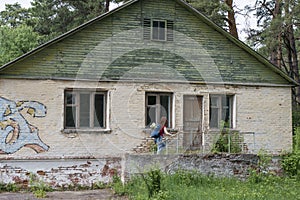 Beautiful red hair woman tourist with backpack exploring abandoned summer camp