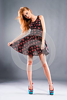 Beautiful red-haired girl on grey background