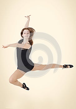 Beautiful red-haired girl at the moment of the jump in dance