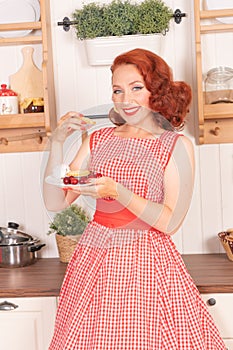 Beautiful red-haired pinup smiling happily girl posing in a retro red dress and white high heels