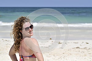 Beautiful red haired woman in bikini smiling