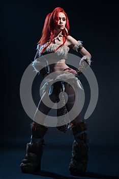 Beautiful red haired woman in stone age clothing