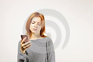 Beautiful red headed young woman posing, showing emotional facial expressions and making funny faces with mobile phone