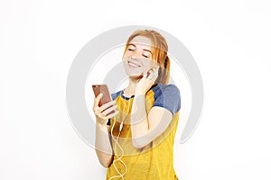 Beautiful red headed young woman posing, showing emotional facial expressions and making funny faces with mobile phone