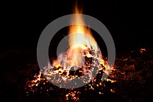 Beautiful red hot glowing ember pile with colorful flames in winter night